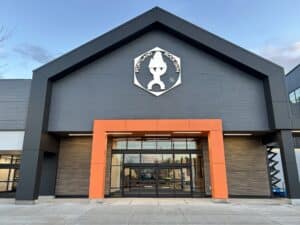 Modern commercial building with a black and orange facade and a unique white logo above the entrance.