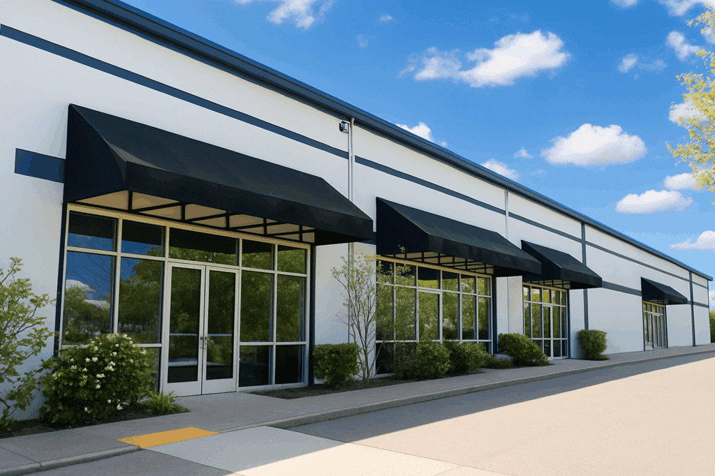 Modern commercial office building with black awnings and large glass windows.