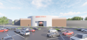 Exterior view of a Crunch Fitness gym with a parking lot filled with cars under a partly cloudy sky.