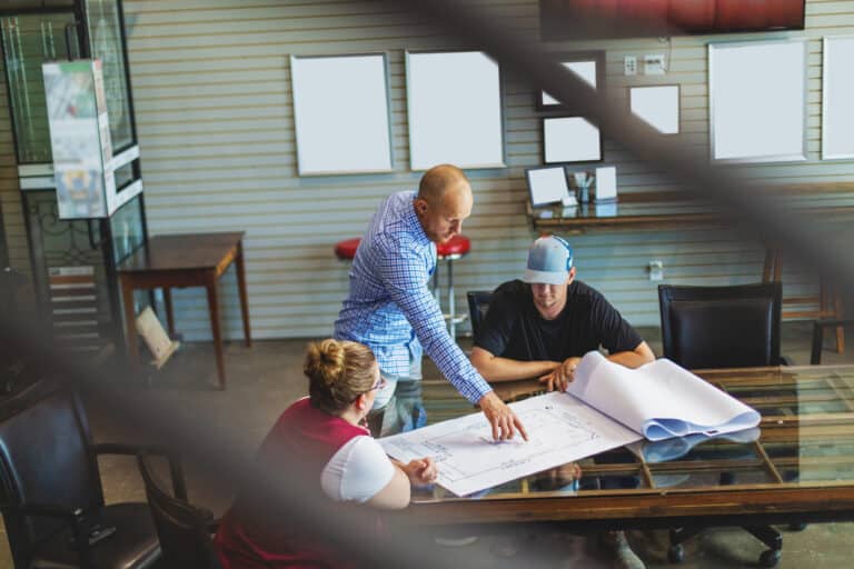 Construction team reviewing blueprints at a meeting table.